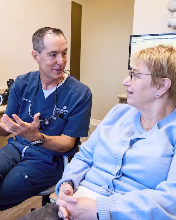 A doctor talking to an older woman regarding dentures at Dental Implant Center at Walnut Creek in Walnut Creek CA 