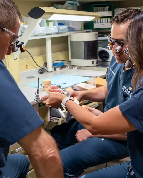 Doctors at Dental Implant Center at Walnut Creek working in a lab with a prosthesis.