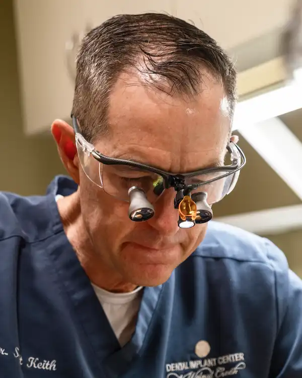 Dr. Keith working while wearing microscopic dental glasses.