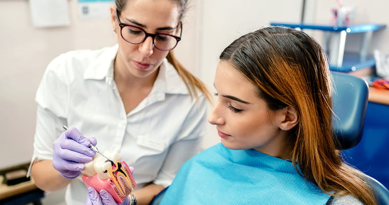A dentist showing a patient an implant model